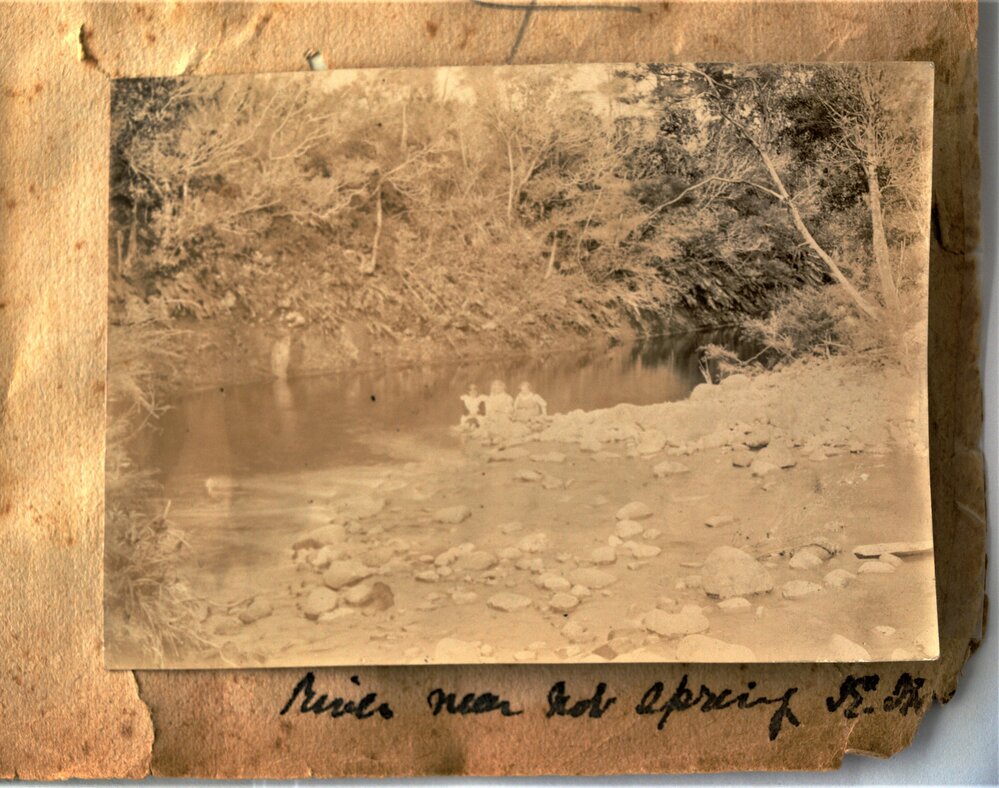 Children sitting on the river bank near the hot springs
