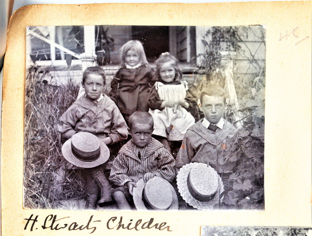 Hugh and Susan Stewart's children sitting on the porch steps.
