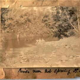 Children sitting on the river bank near the hot springs