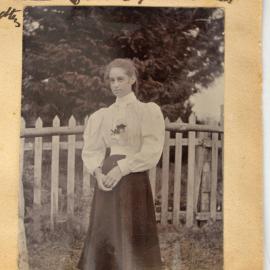 Mary Glestanes in front of a picket fence
