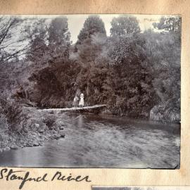 Two girls standing on a bridge over a river near Stanford at Katikati.