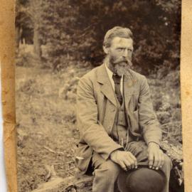 William Taylor sitting on a fallen log.