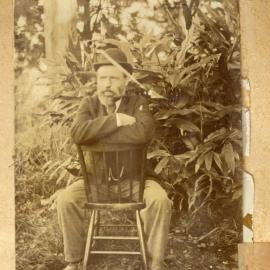 William Taylor sitting on a chair outside.