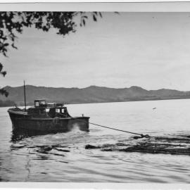 A log raft on its way to the KDV Mill from Matakana Island
