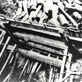 Kauri logs piled behind a dam