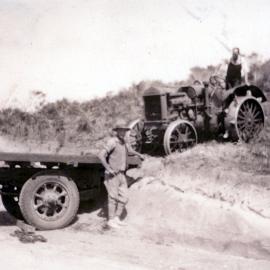 Tractor being loaded on to truck 